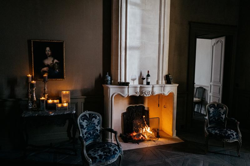 Interior of Calon Ségur chartreuse with bottle sitting above lit fireplace