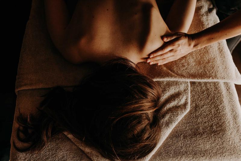 Top shot of girl lying on towels having a shoulder massage in spa