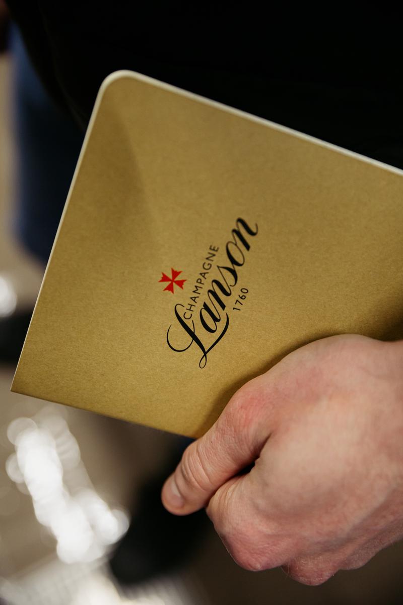 Close up of hand holding Champagne Lanson notebook