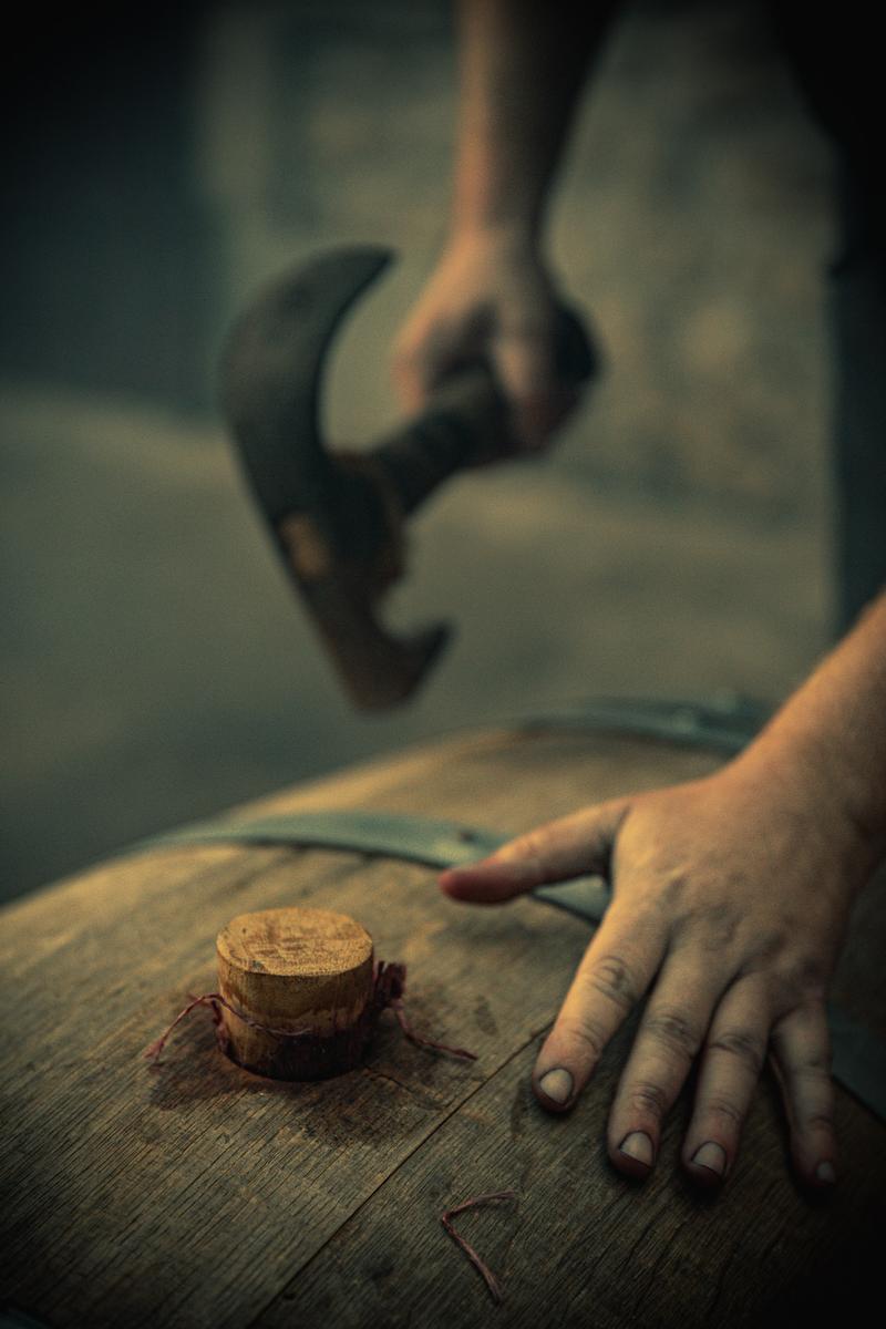 Close up of hammering in a bung into a wine barrel