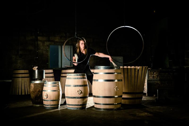 Percussionist drumming on different sized wine barrels